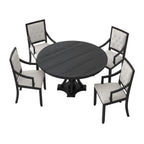 Dining room with a round dark wood table and four chairs on a patterned rug.