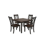 Dining room with wooden table and chairs on a patterned rug, kitchen in the background.