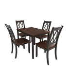 Dining room with wooden table and chairs on a patterned rug, kitchen in the background.