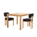 Dining table with two black cushioned chairs in a room with a white cabinet and decorative items.
