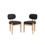 Dining table with two black chairs in a room with light-colored walls and decor.