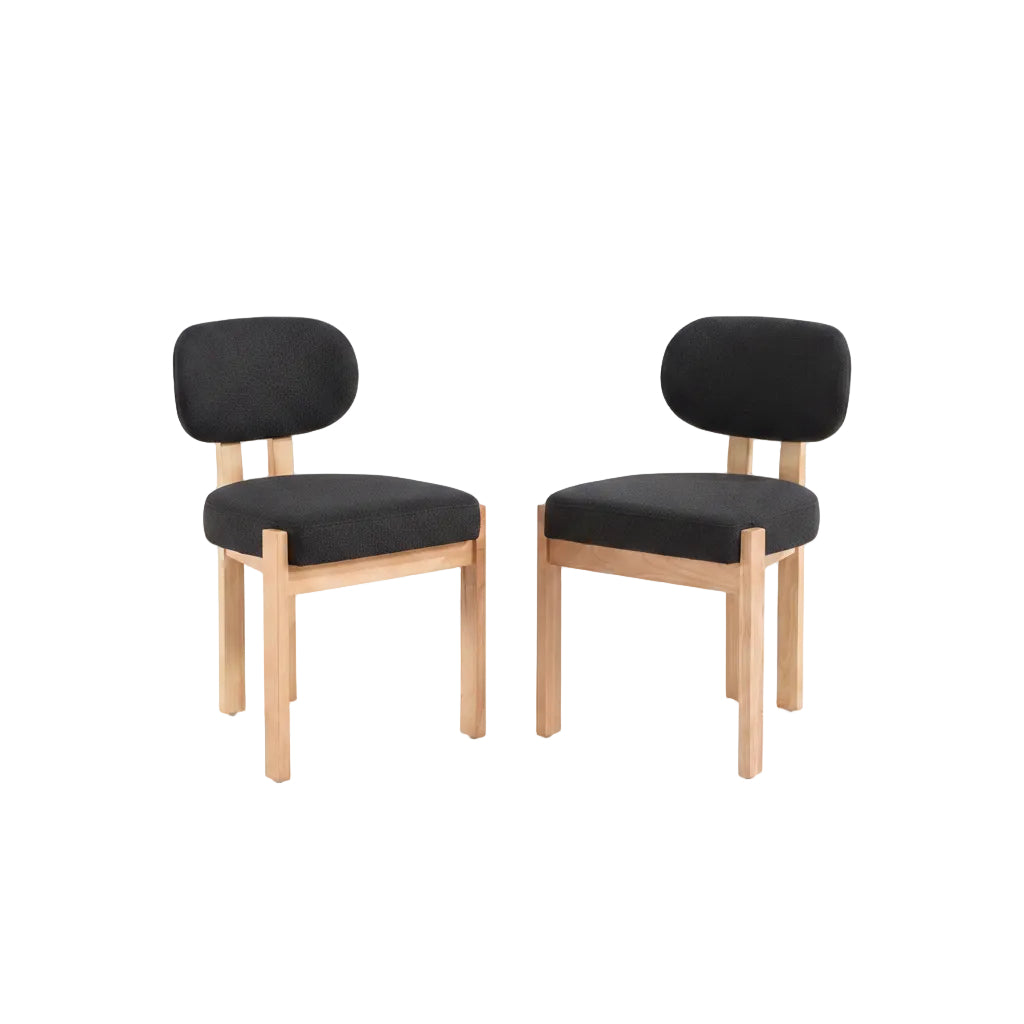 Dining table with two black chairs in a room with light-colored walls and decor.